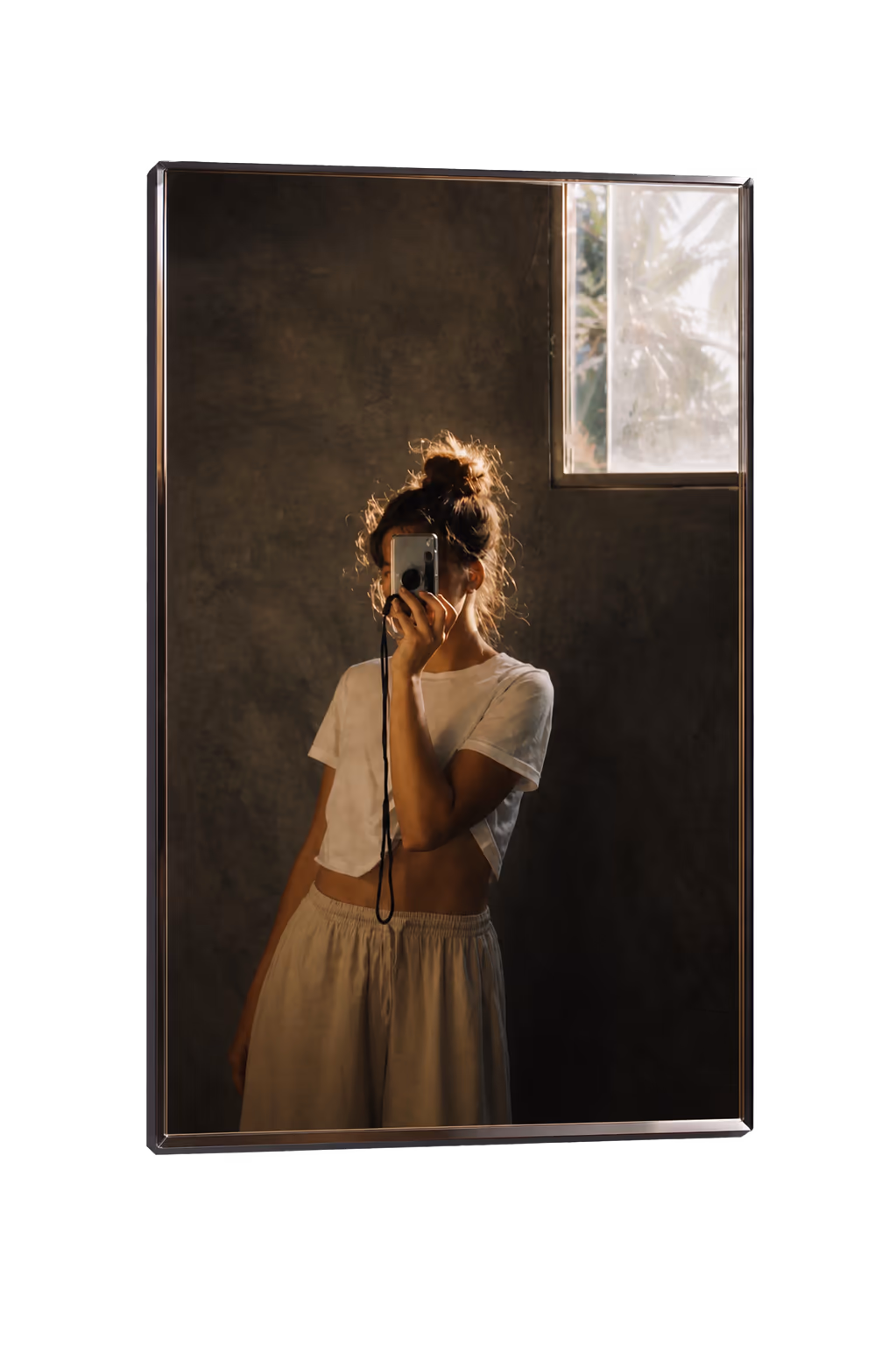 A woman taking a mirror selfie in a stone-walled room
